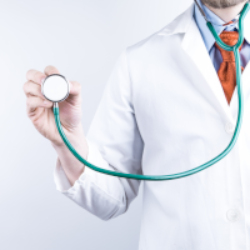 A photo of a white male doctor in a white coat holding a green and silver stethescope out
			to the side.
