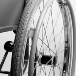 A black and white photo of the wheel of a wheelchair.